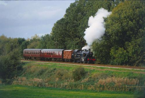a steam train is traveling down the tracks at Best Western Plus Ullesthorpe Court Hotel & Golf Club in Lutterworth