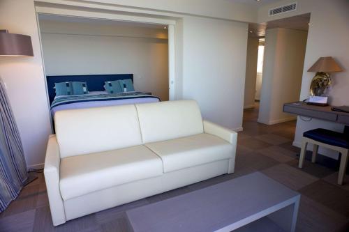 a white couch in a room with a bed at Best Western Premier Santa Maria in LʼÎle-Rousse