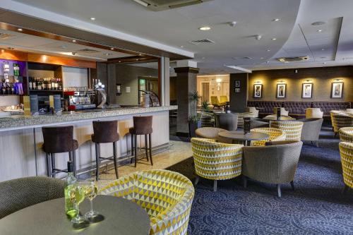 a restaurant with tables and chairs and a bar at Best Western Manchester Altrincham Cresta Court Hotel in Altrincham