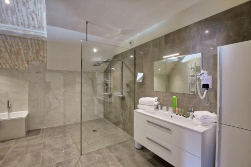 a bathroom with a shower and a sink and a mirror at Best Western Premier Santa Maria in LʼÎle-Rousse