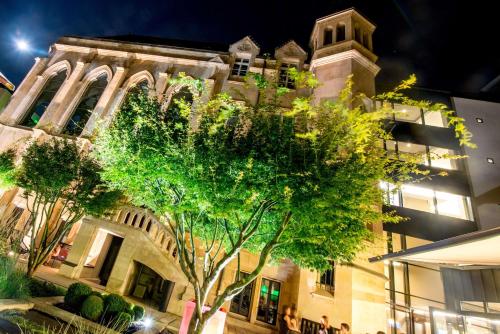 a building with a tree in front of a building at Best Western Premier Hotel de la Paix in Reims