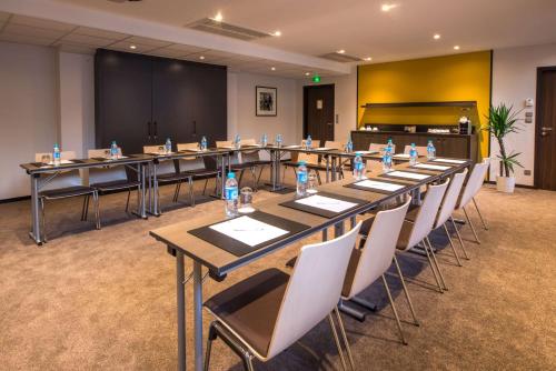 a conference room with tables and chairs and a piano at Best Western Premier Hotel de la Paix in Reims