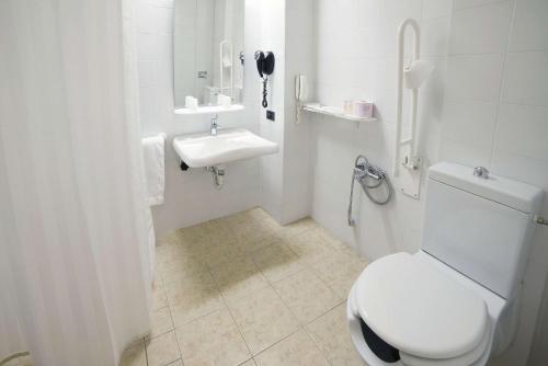 a white bathroom with a toilet and a sink at Best Western Park Hotel in Piacenza