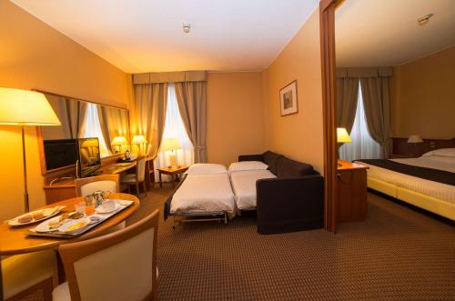 a hotel room with a bedroom with a bed and a table at Best Western Park Hotel in Piacenza
