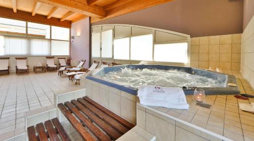 a large jacuzzi tub in a room with chairs at Best Western Classic Hotel in Reggio Emilia