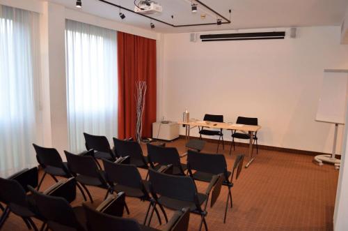 a room with chairs and a table and a screen at Best Western Park Hotel in Piacenza