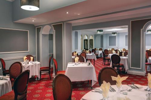a dining room with white tables and chairs at Crewe Arms Hotel in Crewe