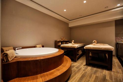 a bath room with a tub and two stools at Best Western Premier Karsiyaka Convention & Spa Hotel in Izmir