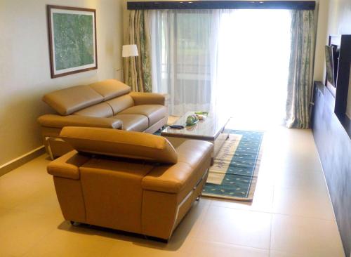 a living room with a couch and a table at Best Western Premier Garden Hotel Entebbe in Entebbe