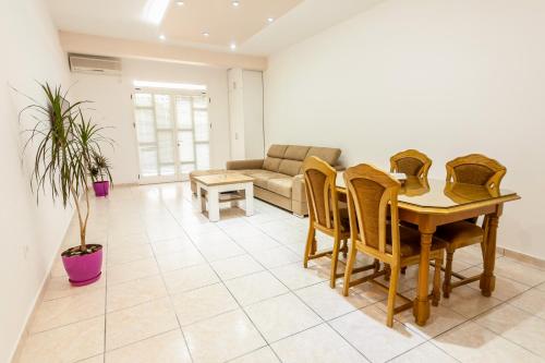 uma sala de estar com uma mesa e cadeiras e um sofá em Apartments Adriatic em Sveti Stefan