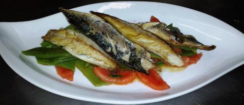 a plate of fish and vegetables on a table at Stella in Quartu SantʼElena