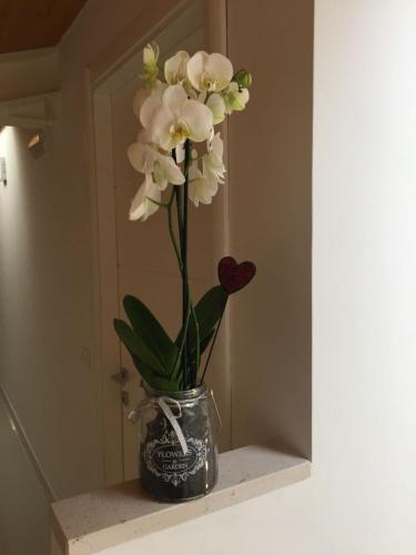 a vase filled with white flowers on a shelf at Palazzo di Fazio Suites in San Severo