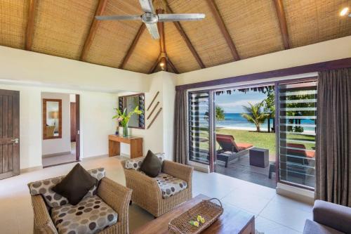 a living room with a ceiling fan and a table at Eratap Beach Resort in Port Vila