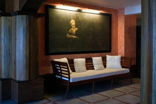 a bench in a room with a painting on the wall at Hotel La Perla Del Golfo in Procchio