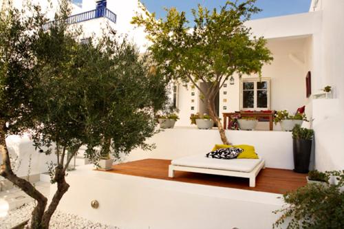 eine Terrasse mit einem weißen Sofa und einigen Bäumen in der Unterkunft Casa Aiora in Adamas