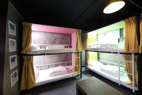 two bunk beds in a room with a table at Calli Hostel in Busan