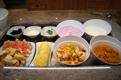 a tray of food with bowls of vegetables and other ingredients at Wanderhotel Kirchner in Bramberg am Wildkogel
