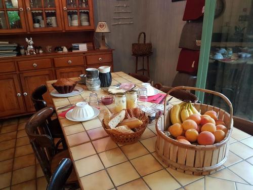 une table avec des paniers de fruits au-dessus dans l'établissement Gîte La Grange au Bois, à Viella
