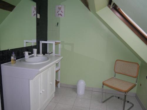 uma casa de banho com um lavatório e uma cadeira em Escale Au Chiteau em Huisseau-sur-Cosson