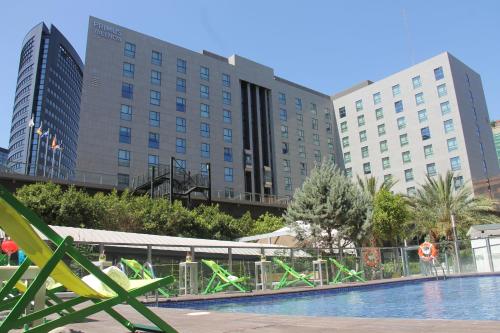 a hotel swimming pool with buildings in the background at Primus Valencia in Valencia