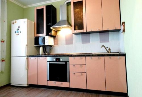 ポドリスクにあるInnDays 50лет ВЛКСМ 18のピンクのキャビネットと白い冷蔵庫付きのキッチンが備わります。