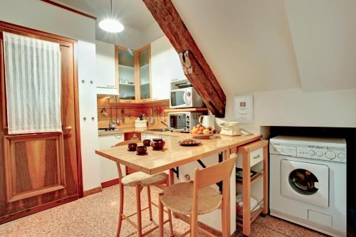 a kitchen with a wooden table with chairs and a stove at Ca' Cortigiane Suite in Venice