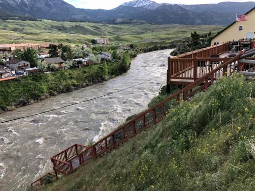 a river with a bridge next to a town at Yellowstone Riverside Cottages in Gardiner