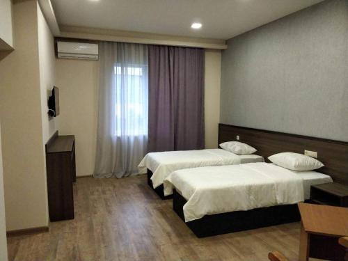 a hotel room with two beds and a window at Riverside Guest House in Yerevan