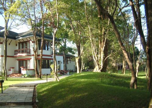a house with a lawn in front of it at Gokarna Forest Resort Kathmandu in Kathmandu