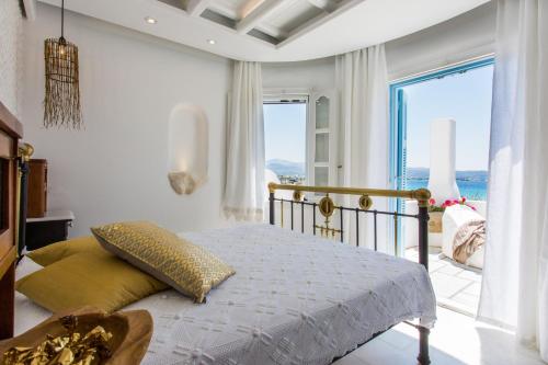a bedroom with a bed with a view of the ocean at Naxian Riviera Exclusive Seafront Suites, Junior Suite in Agios Prokopios