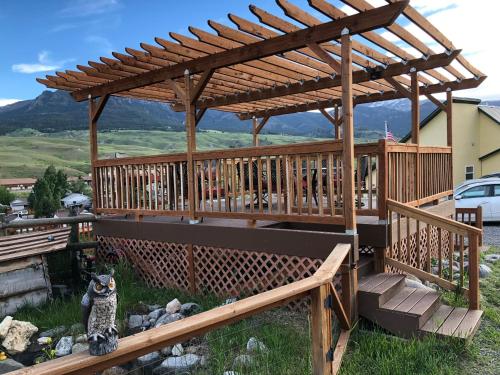 a wooden deck with a wooden pergola at Yellowstone Riverside Cottages in Gardiner