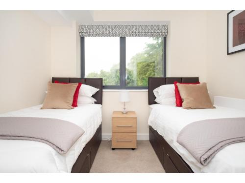 two twin beds in a room with a window at Stylish Flat Near the City Centre - Pass the Keys in York