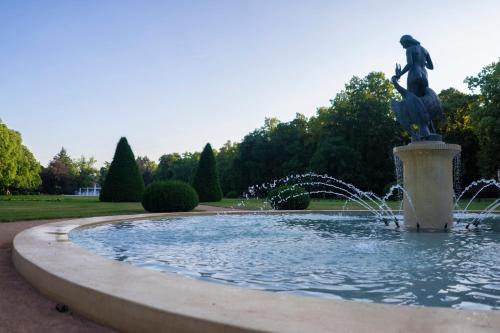 a fountain with a statue in a park at Penzion Homer Poděbrady in Poděbrady