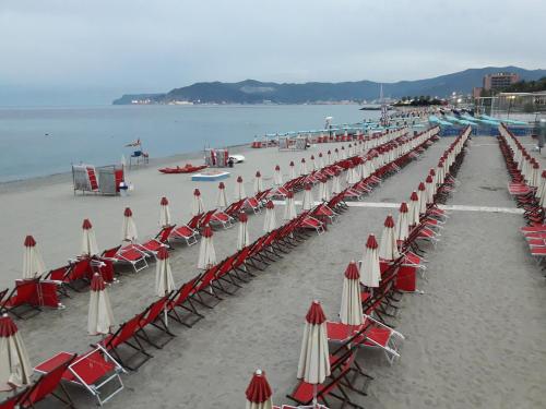 a row of chairs and umbrellas on a beach at Skyline, Casa Vacanze in Savona