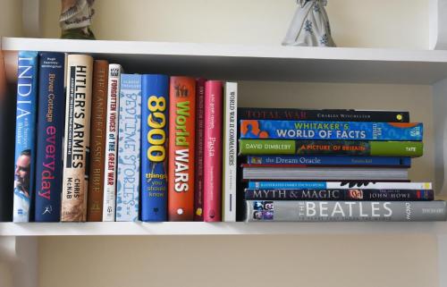 a bunch of books sitting on a shelf at Dale Street Apartments Suite in Leamington Spa
