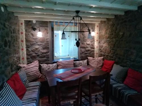 a table and chairs in a room with a stone wall at Villa Notia in Skala Eresou