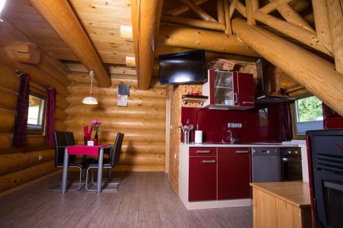 a kitchen with red cabinets and a table in a cabin at Korošec Apartments and Wellness Centre in Mozirje