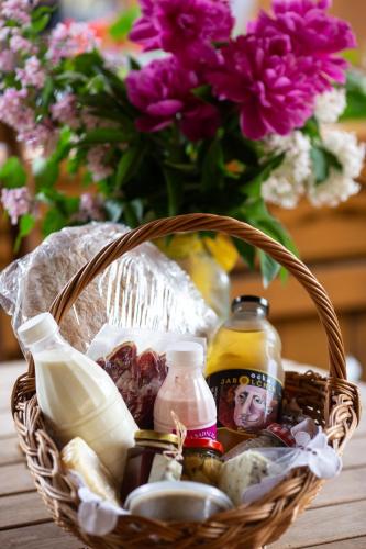 a basket filled with food and a vase of flowers at Korošec Apartments and Wellness Centre in Mozirje