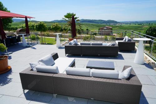 a patio with couches and tables and a view at Köpfers Steinbuck in Bischoffingen
