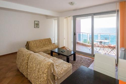 a living room with a couch and a view of the ocean at Apartments Palma in Dobra Voda
