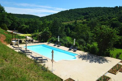 - une vue sur la piscine située sur une colline dans l'établissement Le Manoir, à Souillac