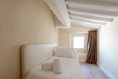 a white bed in a room with a window at Residenza D'Epoca La Basilica in Florence
