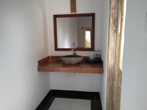 a bathroom with a sink and a mirror at Krisna Homestay in Pemuteran