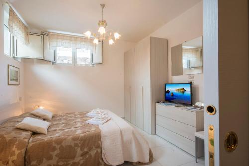 a small bedroom with a bed and a television at Villa Armonia in Praia a Mare