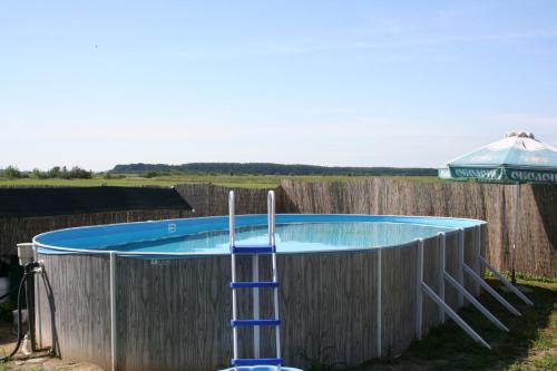 a swimming pool with a ladder around a fence at Hotel Helikon in Yanoshi