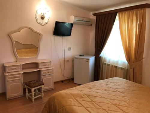 セヴァンにあるArmenia VanSevan Hotelのベッドルーム(ベッド1台、鏡、テレビ付)