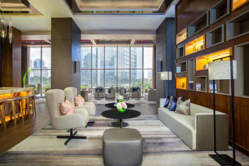 a lobby with a waiting area with couches and a table at Ascott Sudirman Jakarta in Jakarta