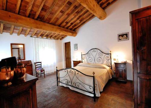 a bedroom with a bed and a wooden ceiling at Hotel Giogliano in Radicondoli