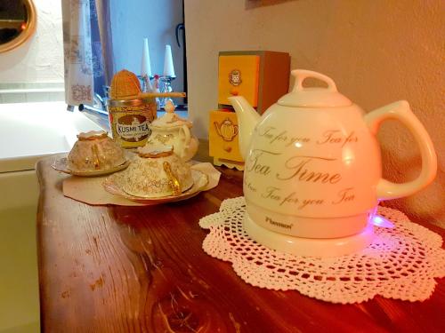 a tea pot sitting on top of a wooden table at Maison Du-Noyer Chambres et Tables d'Hotes in Aosta