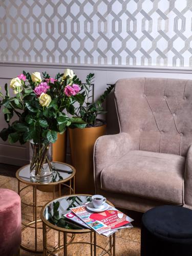 a living room with a couch and a vase of flowers at Hotel Cristal Park in Dąbrowa Tarnowska